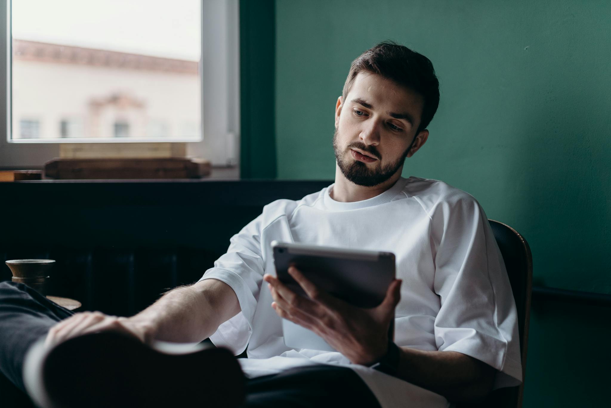 Man in White Shirt Holding an Ipad